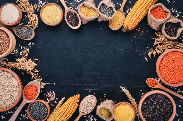 粗和谷物的集合。荞麦, 扁豆, 大米, 小米, 大麦, 玉米, 黑米。在黑色的背景。顶部视图。复制空间.
