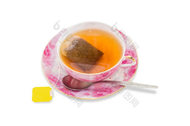 一杯带茶包的茶，茶匙放在茶碟上
