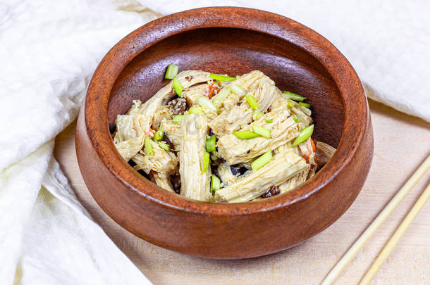 亚洲富珠色拉（鱼子酱、豆腐乳、<strong>豆腐皮</strong>），在圆圆的木制碗中，背景浅.