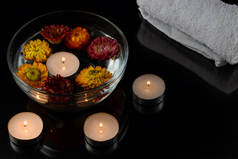 透明玻璃碗与水和干花，水鸟燃烧蜡烛白色毛巾黑色背景