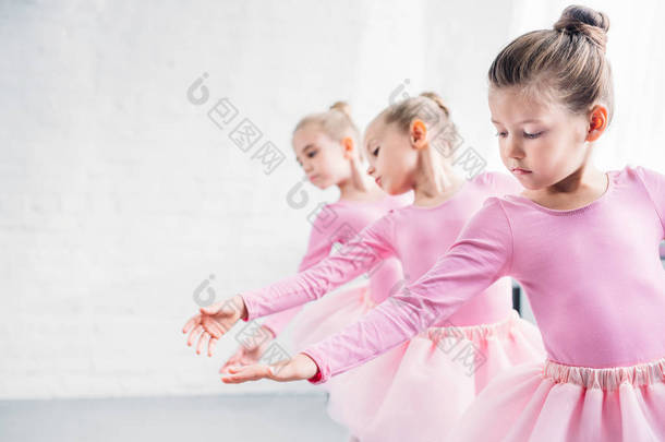 美丽的小孩子在粉红色的衣服跳舞在芭蕾舞室