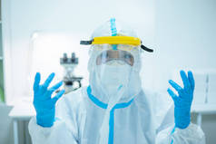 医生女士穿着隔离衣或防护服，戴着外科口罩，以防止考拉病毒的传播- -她在医院里戴着手套