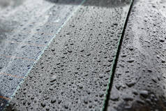 具有疏水作用的黑色车身上的雨滴特写.