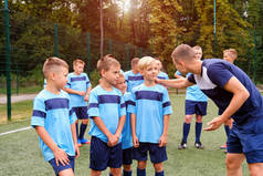 穿着足球制服的孩子们在赛前听教练讲解.