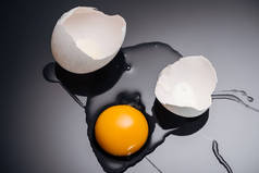 关闭新鲜粉碎的鸡蛋与蛋黄, 蛋白质和蛋壳在黑色背景