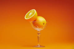 在橙色背景的玻璃新鲜成熟的橙子的特写镜头视图