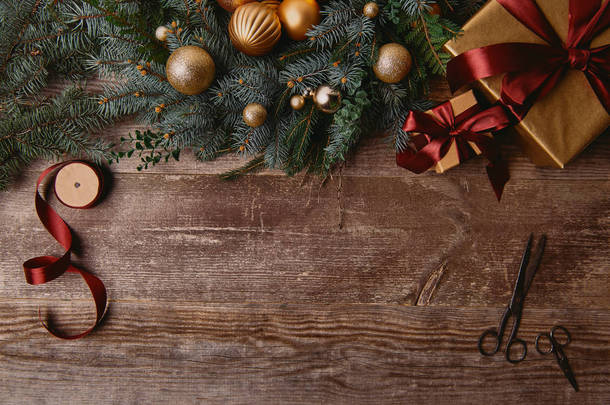圣诞节礼品盒, 杉木花环, 丝带线轴和木桌剪刀的顶部视图