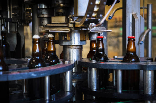 在工厂放置瓶盖的过程中，啤酒瓶在顶部（高依索图像）)