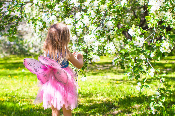 可爱的小女孩，在 5 月的朵朵苹果树花园