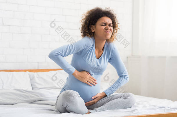劳工收缩。 腹部疼痛的孕妇