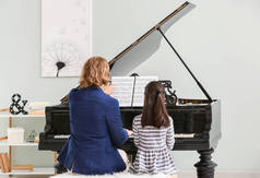 男人教小女孩弹钢琴