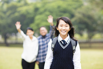 可爱的年轻学生女孩与家长在学校图片