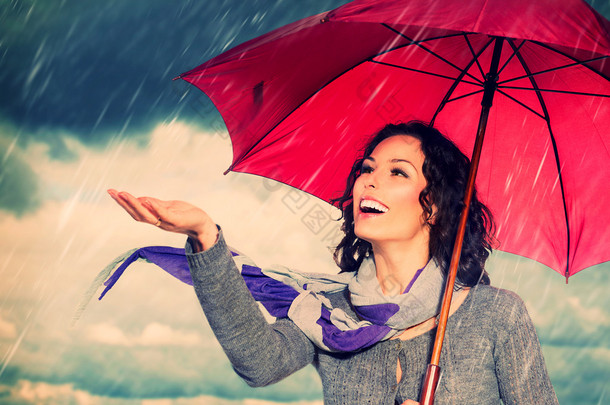 在秋天的雨背景微笑着把伞的女人
