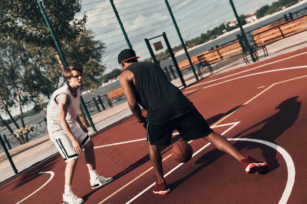 两名<strong>运动员</strong>在户外篮球竞技场上打篮球