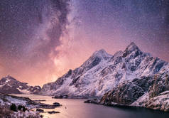 夜间在水面上安装和反射。在夜间的海湾和山脉。挪威山上的银河.