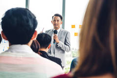 商务人员站在一群人面前，在大厅或会议室举行的会议研讨会上进行咨询。演示和指导概念