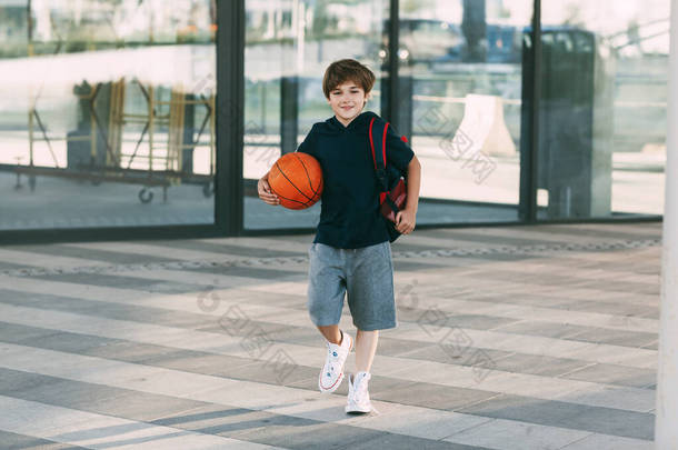 一个快乐的男孩，背着背包和篮球。一个男孩急于打篮球练习.培训、<strong>教育</strong>