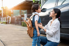 妈妈准备早上开车送孩子回学校。妈妈在开学前说再见。教育与重返学校的概念。幸福的家庭和学龄前儿童和教育