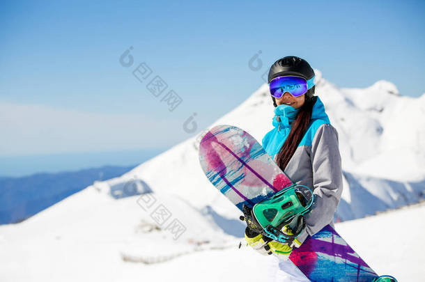 妇女徒步滑雪头盔的相片在雪山背景上滑雪板