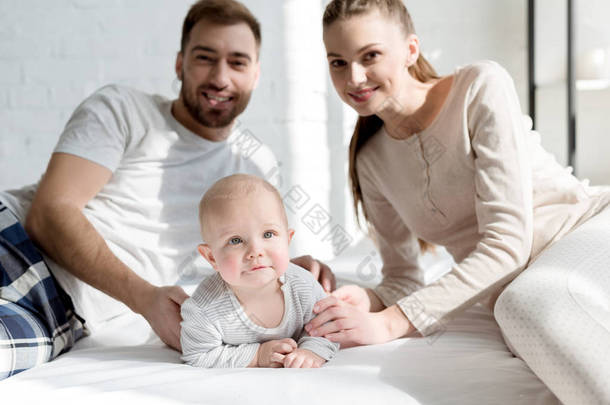 微笑的父母与小儿子在床上