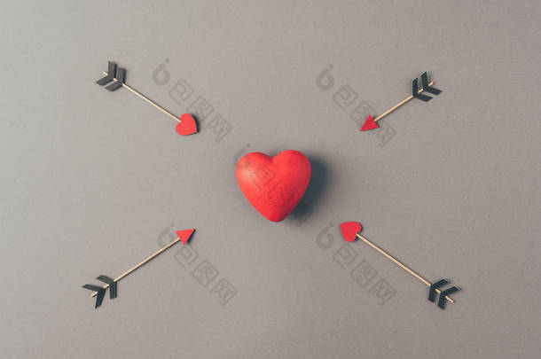 在灰色的四个箭头之间的红色心脏的顶部视图，情人节概念