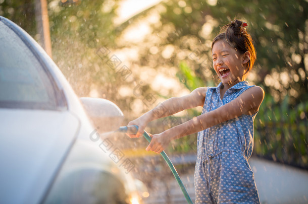 快乐<strong>的</strong>亚洲女孩洗车水溅和阳光在家里
