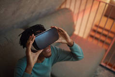 非洲裔美国人穿着VR装备，沉浸在未来派的内部体验中，有着很高的视角，复制空间