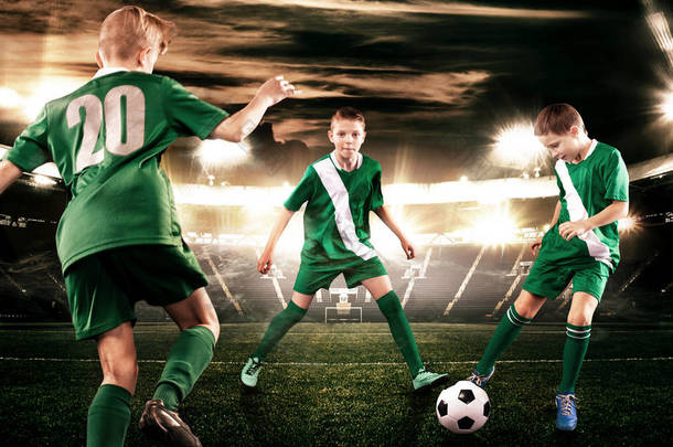 孩子-足球运动员男孩向前在橄榄球运动服在体育场与球。体育概念.