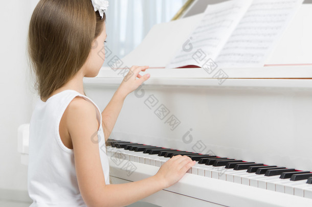 <strong>小女孩</strong>在弹钢琴的白色连衣裙的侧视图