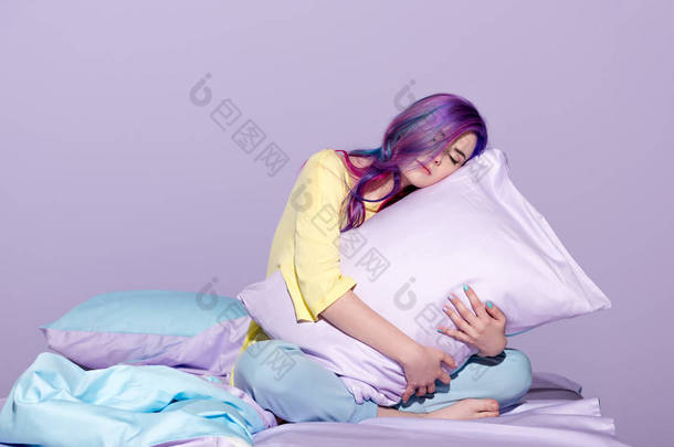 昏昏欲睡的年轻女子坐在床上拥抱枕头