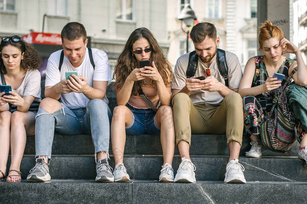 一群朋友一起用智能手机。年轻人沉迷于新的技术趋势。青春,<strong>新一</strong>代互联网友谊的理念.感情上的孤立和压抑