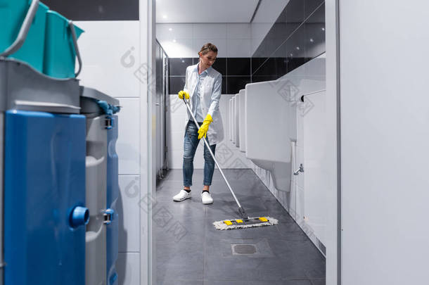 清洁夫人在男士洗手间拖地板