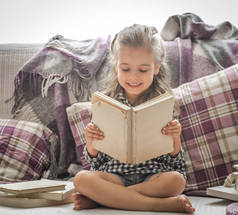 在沙发上读书的小女孩