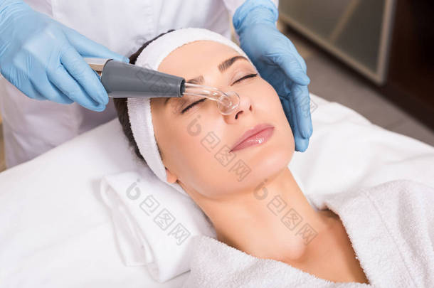 美容师做物理治疗后, 在美容院的妇女脸上的达森维化设备