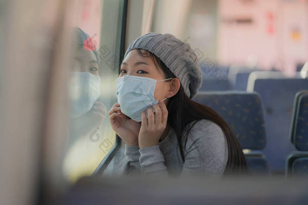 年轻迷人而快乐的亚洲女人，戴着面具，开着新的普通病毒在火车<strong>车厢</strong>里旅行- -甜美的韩国姑娘兴奋而快乐地透过火车<strong>车厢</strong>窗户看过去