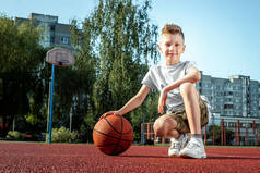 篮球场上一个带篮球的男孩的肖像。运动生活方式的概念，训练，运动，休闲，度假.