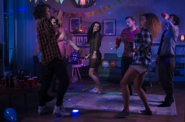 在学院家庭聚会上:不同的朋友团体有乐趣,跳舞和社交。男孩和<strong>女孩</strong>在圈子里跳舞。迪斯科霓虹灯照明室.
