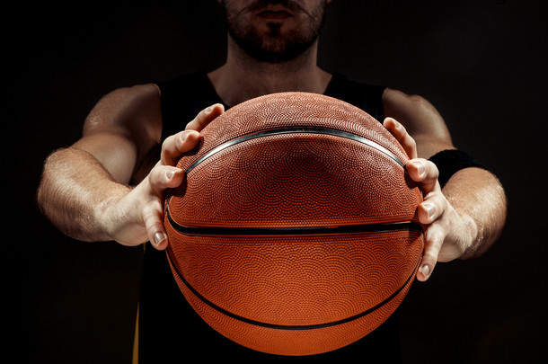 一名拿着篮子球在黑色<strong>背景</strong>上的篮球运动员的剪<strong>影视</strong>图
