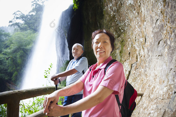  亚洲的年长夫妇与瀑布山中远足