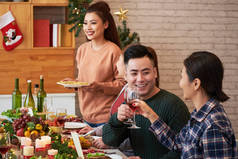 越南年轻人在圣诞餐桌上聊天、吃喝葡萄酒