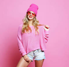 穿着粉色套头衫、头戴粉色帽子、穿着时髦休闲装的年轻女子的时尚肖像画。嬉皮士风格.
