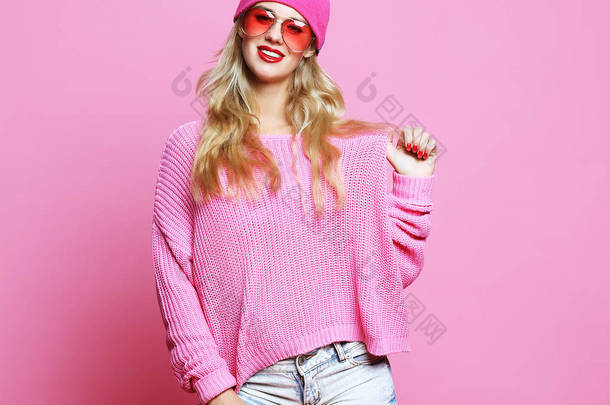 穿着粉色套头衫、头戴粉色帽子、穿着时髦休闲装的年轻女子的时尚肖像画。嬉皮士风格.