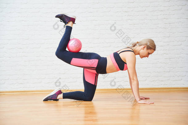 运动妇女做<strong>健康</strong>的运动，健身球隔离在墙面背景。普拉多，在家里和体育馆里锻炼