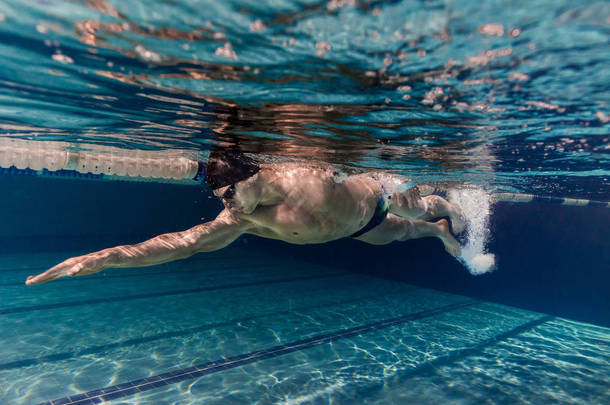<strong>泳池游泳</strong>帽及护目镜训练中的年轻<strong>游泳</strong>者水下图片