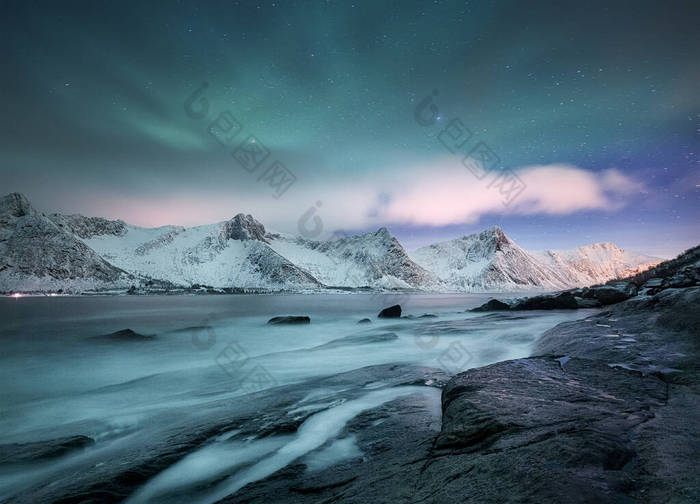 挪威Lofoten岛上的Aurora borealis 。高山上方的绿色北极光。带着极光的冬夜风景.挪威的自然背景.