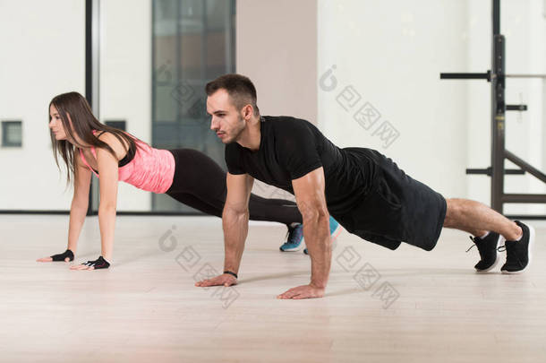 作为在健身房健身训练的一部分做俯卧撑的夫妇