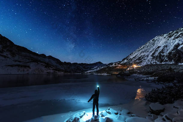冬季的星空，波兰鞑靼人靠近一个被冰覆盖的高山湖面