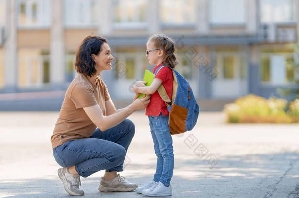 小学的父母和<strong>学生</strong>是紧密联系在<strong>一起</strong>的.背着背包的女人和女孩。开始上课。秋天的第一天.