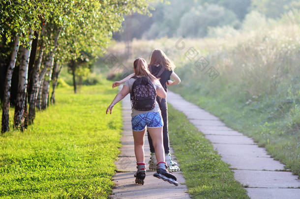 Yaslo, 波兰-2018年7月9日: 在阳光照射下, 两个女孩在绿叶间打滚。健康的生活方式和关爱的身影。体重减轻额外的公斤。晨跑.