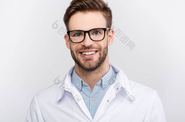 戴着<strong>眼镜</strong>微笑的医生，看着用灰色隔离的相机 